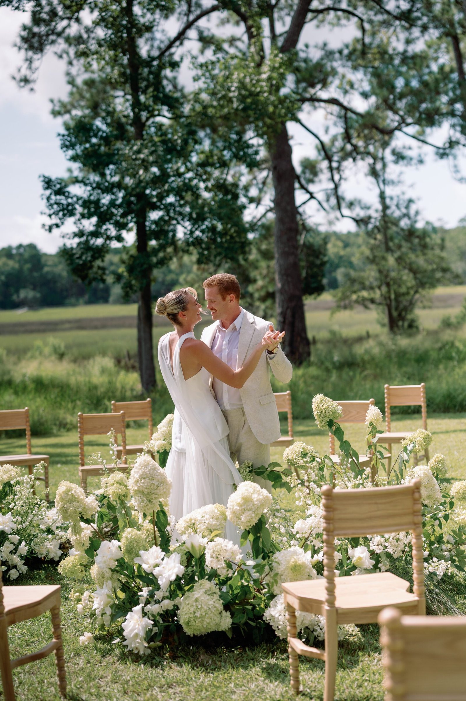 Couple exchanging vows during an outdoor wedding ceremony at Pine Creek Place near Charleston